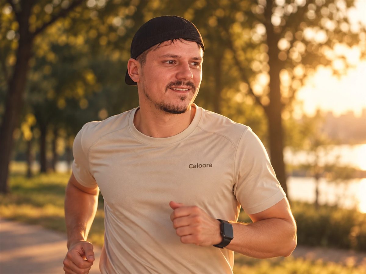 Man in a Caloora t-shirt running in a park at sunset